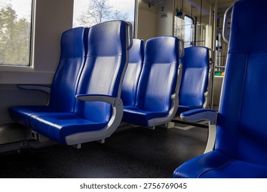 Empty blue train seats in second-class carriage at Deventer station. High quality photo