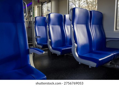 Empty blue train seats in second-class carriage at Deventer station. High quality photo