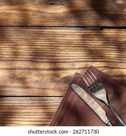 Empty Board With Fork And Knife On Wooden Table. Top View