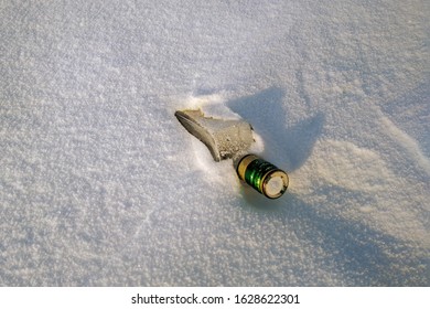 An Empty Bottle Of Alcohol Is Lying In The Snow