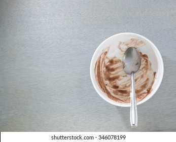An empty bowl with ice cream stain over a wooden background ,top view
