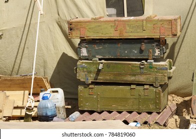 Empty boxes from under shells.Stand near a military tent.