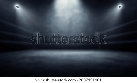An empty boxing ring is dramatically lit by bright spotlights from above, creating a sense of anticipation and focus on the central area.