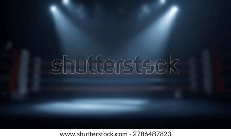 An empty boxing ring is illuminated by bright spotlights in a dark arena, highlighting the ropes and canvas.