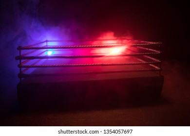 Empty boxing ring with red ropes for match in the stadium arena. Creative artwork decoration. Foggy background with light. Selective focus