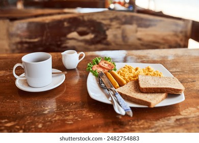 Empty, breakfast and coffee on table in home with eggs for nutrition, protein or healthy dish in morning. Weekend, toast and knife with fork for eating food, hospitality and room service at lodge - Powered by Shutterstock