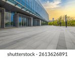 Empty brick floor and glass facade office building background at sunrise.