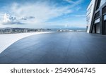 Empty brick floor and modern city buildings with skyline and mountains