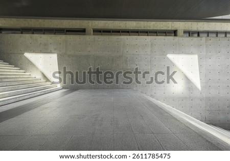 Empty brick floor perspective view towards concrete stairs and wall with geometric recessed light features background.