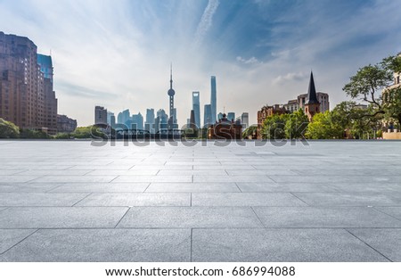 empty brick platform with city skyline in background.