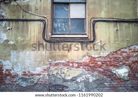 Empty Brick Wall Texture with window and cabels. Distressed Wall Surface. Grungy Wide Brickwall. Grunge Stonewall Background. Shabby Building Facade With Damaged Plaster.  Copy Space. Vintage effect.