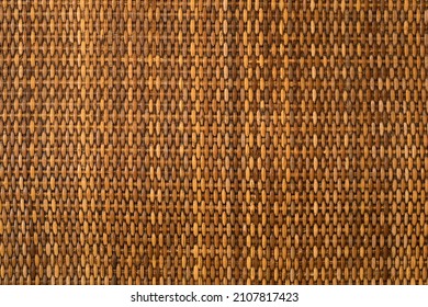 empty brown nature rattan table by top view or yellow wooden weave wall handmade and wood texture pattern for background
