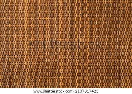 empty brown nature rattan table by top view or yellow wooden weave wall handmade and wood texture pattern for background
