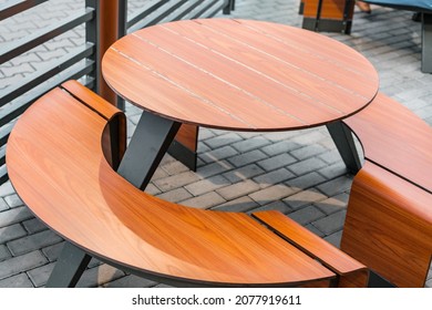 Empty Brown Round Table And Benches Stands Near Fast Food Restaurant. Outdoor Cafe. Urban. No People. All-in-one. Entire. Street. Solid