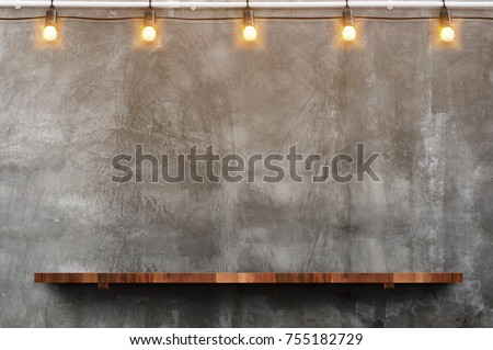 Empty brown wood plank board shelf at grunge concrete wall with light bulb string party background,Mock up for display or montage of product or design.