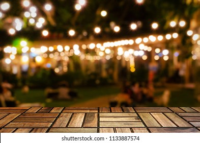 empty brown wooden floor or wooden terrace with abstract night light bokeh of night festival in garden, blurred background, copy space for display of product or object presentation, vintage color tone