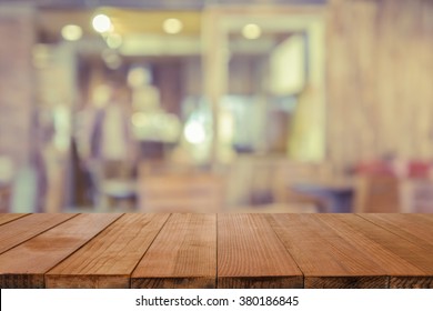 Empty brown wooden table and Coffee shop interior with some people meeting blur background with bokeh image,can be used for montage or display your products - Shutterstock ID 380186845