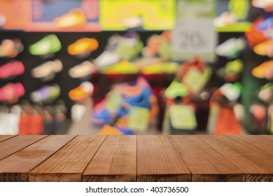 Empty brown wooden table and De focused/blurry background of Sports clothing store in Inter Sport store,with bokeh image,can be used for montage or display your products