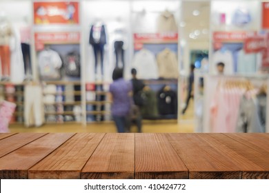 Empty brown wooden table and De focused/blurry background of Sports clothing store in Inter Sport store,with bokeh image,can be used for montage or display your products