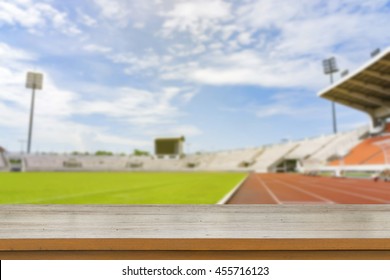 Empty Brown Wooden Table Top On Blurred Background Of Red Running Tracks In Sport Stadium - Can Be Used For Display Or Montage Your Products