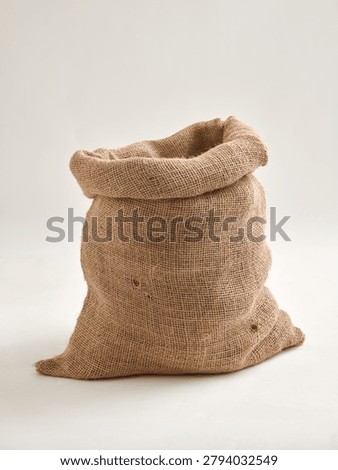 Empty burlap sack isolated on a white background. Rustic jute bag commonly used for storing agricultural products, grains, spices, coffee beans, potatoes and other farm produce. Suitable for packaging, storage and mockup concepts.