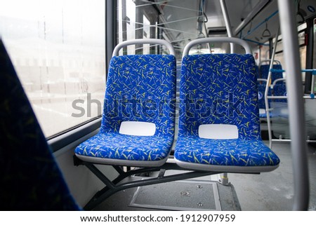 Empty bus interior. Blue seats without passengers. Public transport. Transportation of passengers by public transport. Ergonomic interior of the bus. Travel to other cities.