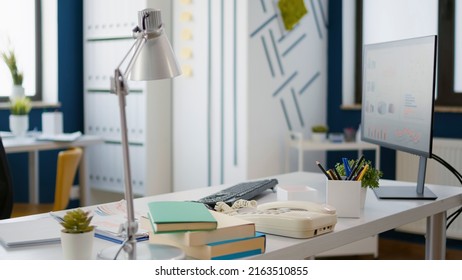 Empty Business Workspace With Office Supplies And Technology To Work On Startup Growth. No People In Professional Company Workplace With Economic Statistics And Research On Computer.