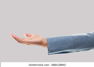 Empty Businesswoman Hand Holding Isolated On Gray Background. Blank Woman Hand And Blue Suit Sleeve.