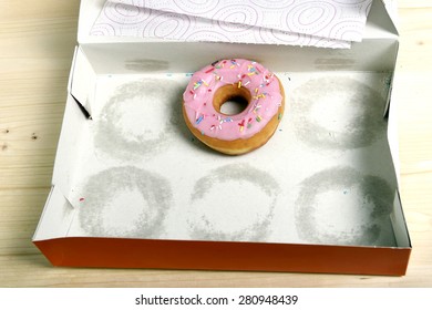 empty cakes box with only one tempting and delicious donut with toppings left in unhealthy nutrition and sugar and sweet cake addiction concept