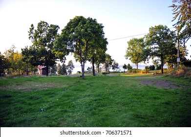 Empty Camp Site In Late Summer. Light Disappearing Ocean View In The Background.  Green Lawn And Trees.  Loevoeya Camping In Horten, Norway.