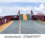 Empty Car Ferry Deck with Raised Loading Ramp Under Blue Sky 