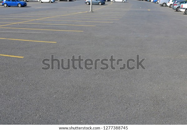 Empty\
car space between parked cars. Modern parking\
lot.