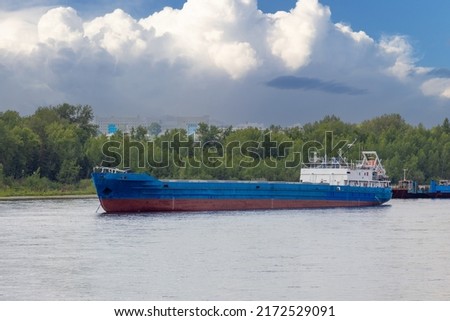 An empty cargo barge on the Yenisey river in Siberia, Russia. Barge is a flat-bottomed boat for river and canal transport of bulk goods