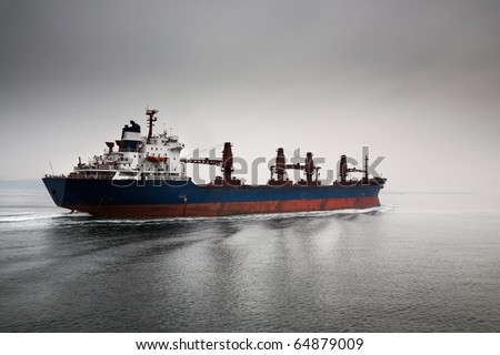 The empty cargoship going through passage Dardanelless, Turkey, in rainy weather