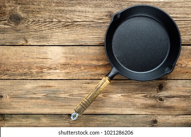 Empty Cast Iron Frying Pan On Wooden Culinary Background, View From Above.