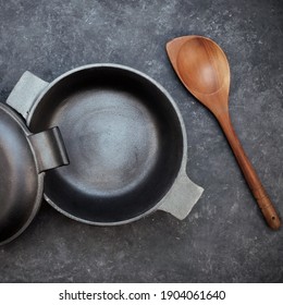 Empty Cast Iron Pot On Grunge Black Table, Overhead View. Cast Iron Pot With Lid On Black Isolated Background Top View. 