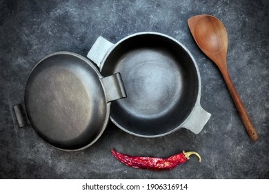 Empty Cast Iron Pot On Grunge Black Table, Overhead View. Cast Iron Pot With Lid On Black Isolated Background Top View. 