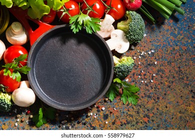 Empty Cast Iron Skillet And Fresh Organic Vegetables On A Dark Background, Top View, Horizontal