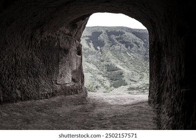 Empty cave looking out. Darkness inside Mysterious empty interior Cave in Caucasian Mountain. Big empty cave with cut out entrance. Arch tunnel entrance natural rock cave on background. - Powered by Shutterstock