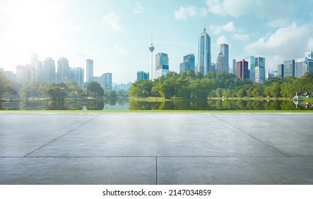 Empty cement floor with lake garden and modern city skyline in background. - Shutterstock ID 2147034859
