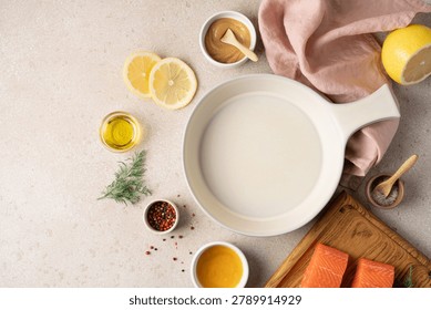 Empty ceramic baking dish surrounded by fresh ingredients for preparing honey mustard lemon salmon, including lemon, honey, mustard, herbs and seasonings. Healthy home cooking concept with high protein meal preparation, wholesome ingredients and rustic kitchen styling. Modern wellness nutrition, clean eating lifestyle and recipe background with copy space