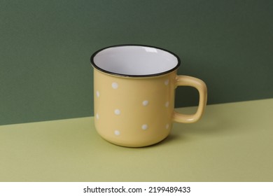 Empty Ceramic Cup With Polka Dots On A Green Two Tone Background