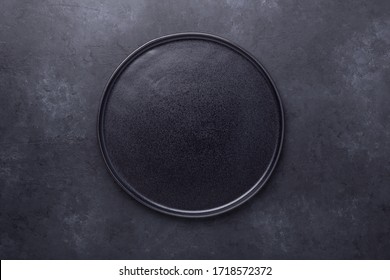 Empty ceramic plate on dark stone background Copy space Top view - Image