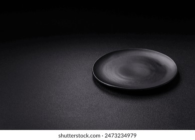 Empty ceramic round plate on dark textured concrete background. Cutlery, preparation for dinner - Powered by Shutterstock