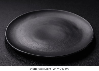 Empty ceramic round plate on dark textured concrete background. Cutlery, preparation for dinner - Powered by Shutterstock