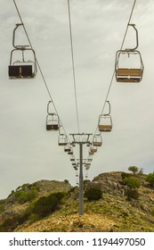 Empty Chair Lift On The Mountainside In Summer
