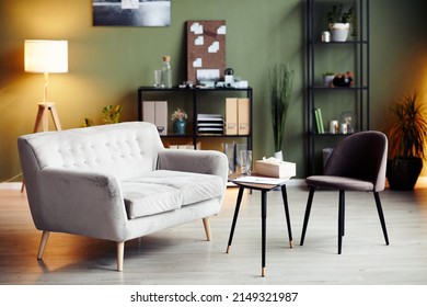 Empty chair and sofa iin front of small table in office of psychologist - Shutterstock ID 2149321987