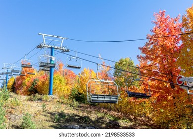 Empty chairlift on an autumn foliage background. Ski lift used to walk in the wood in autumn.