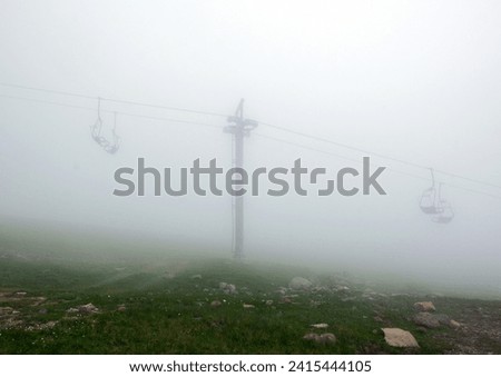 Empty Chairlifts with No People in Thick Fog on Abandoned Ski Elevator. Mistical Dramatic View. High quality photo