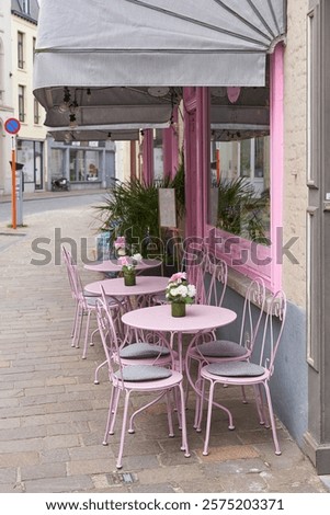  Empty chairs in front of a street cafe in the old town of Bruges in Belgium                              